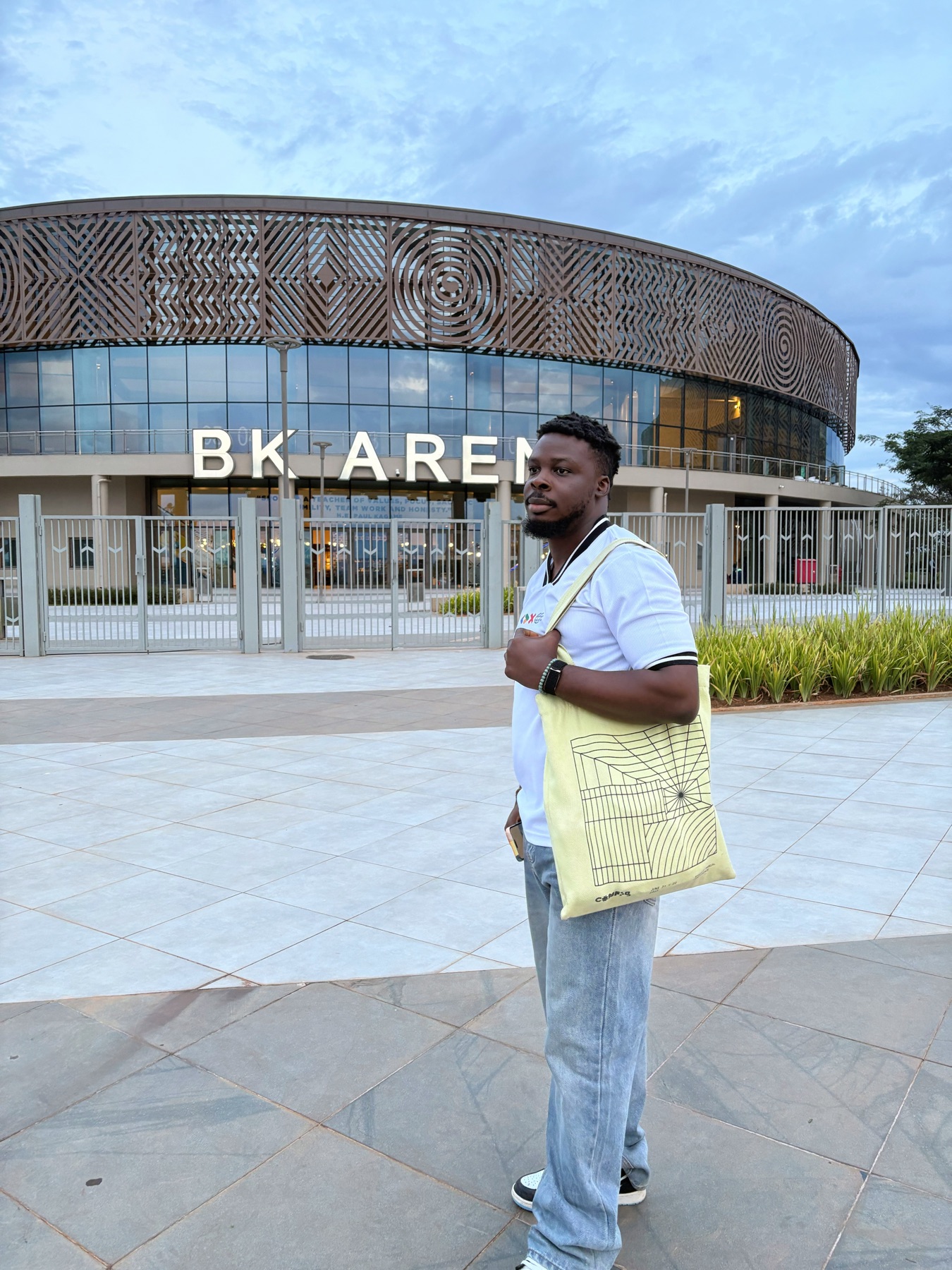 Oluwa Tobiloba standing in front of the patterned BK Arena facade